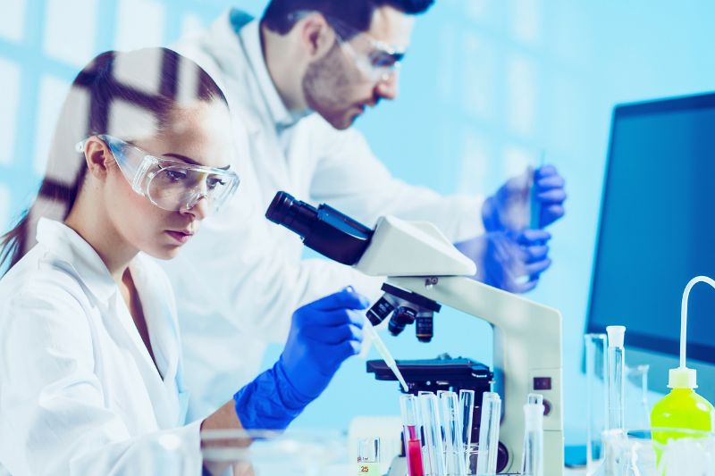 two scientists in a lab using lab equipment